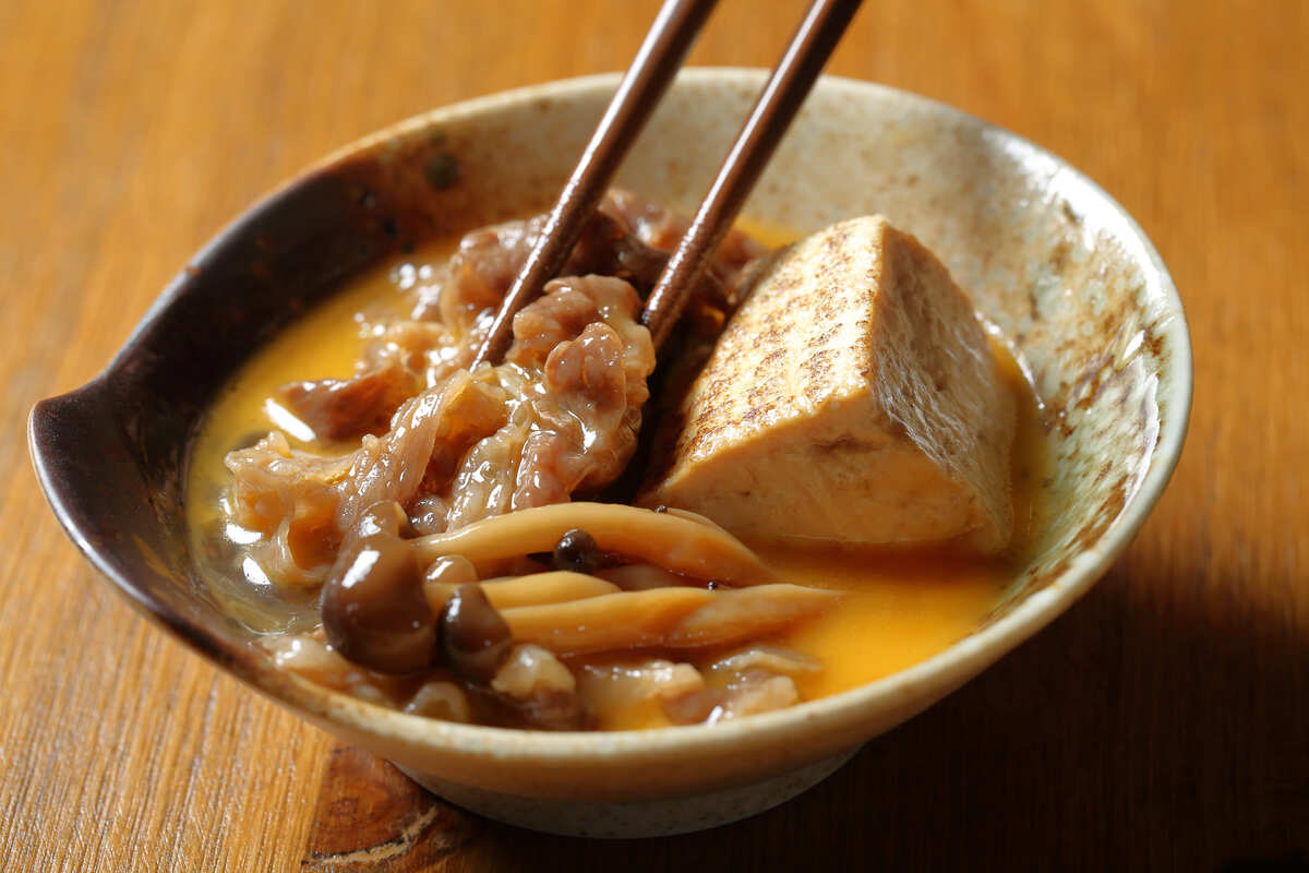 Dipping sukiyaki in raw egg